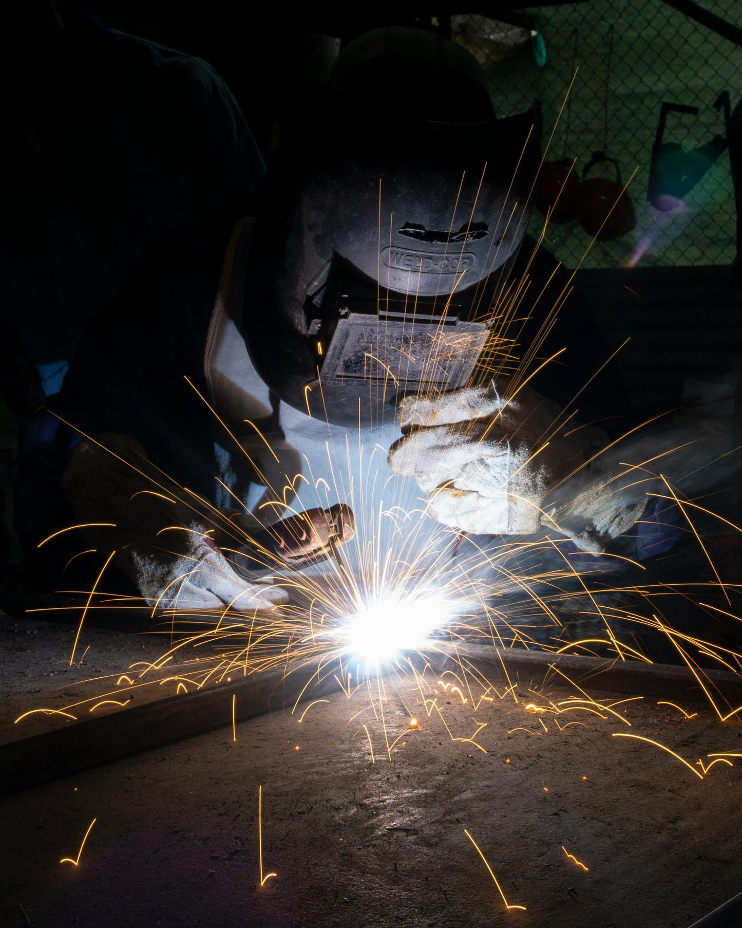 A person welding in a machine shop.