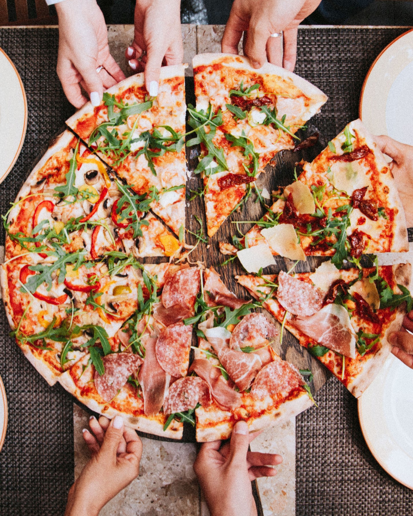 Top down view of pizza slices being picked up.