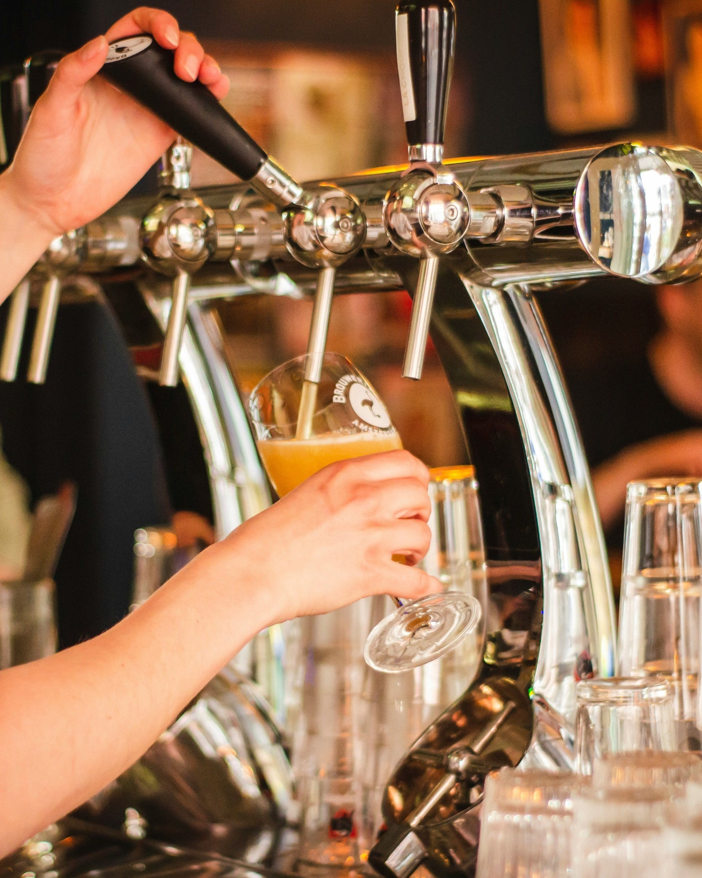 Person pouring beer from tap into a glass