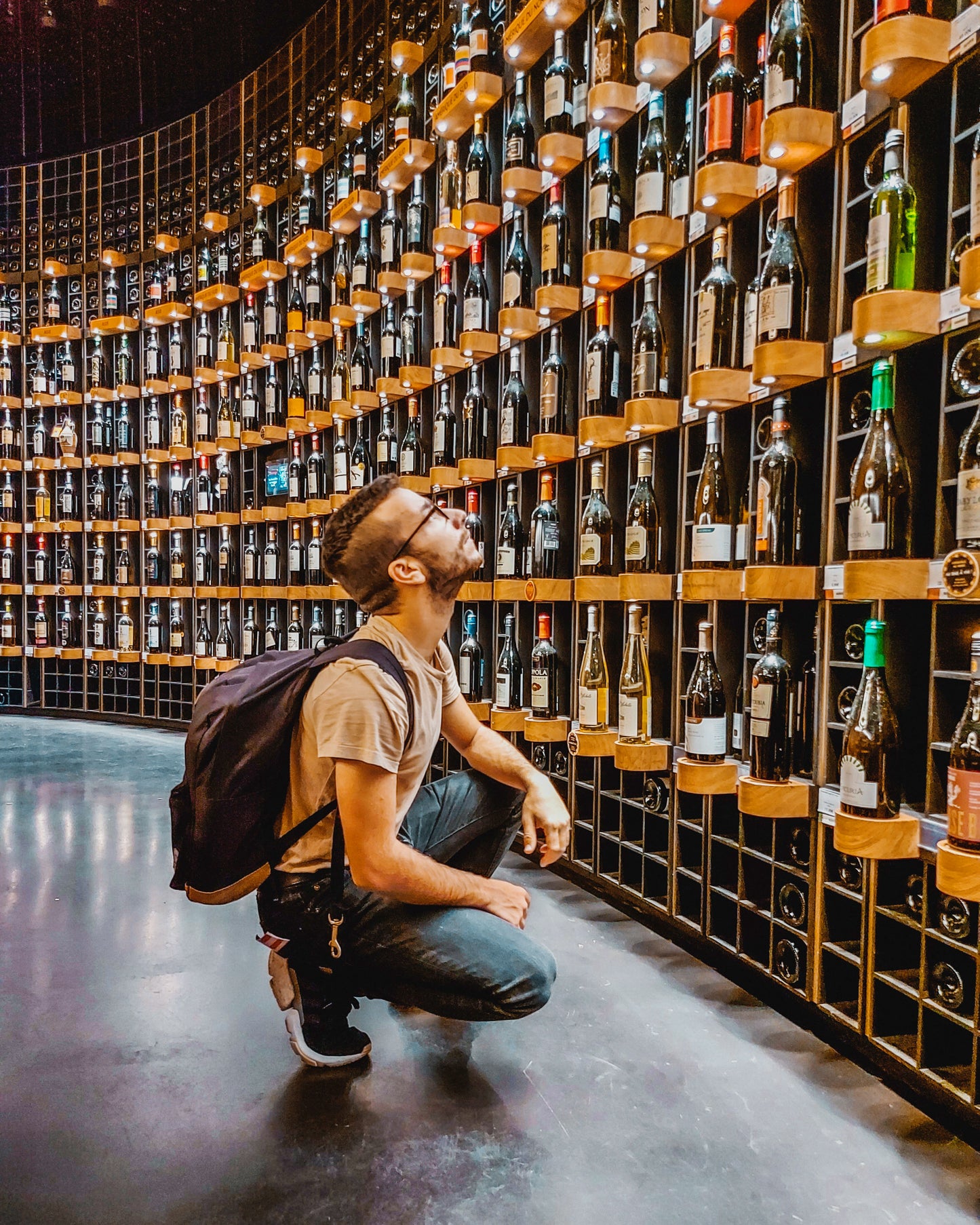 A person deciding which liquor bottle they want from the rows.