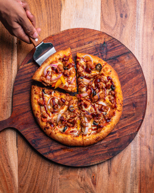 Top down view of a pizza with a slice of pizza being picked up.