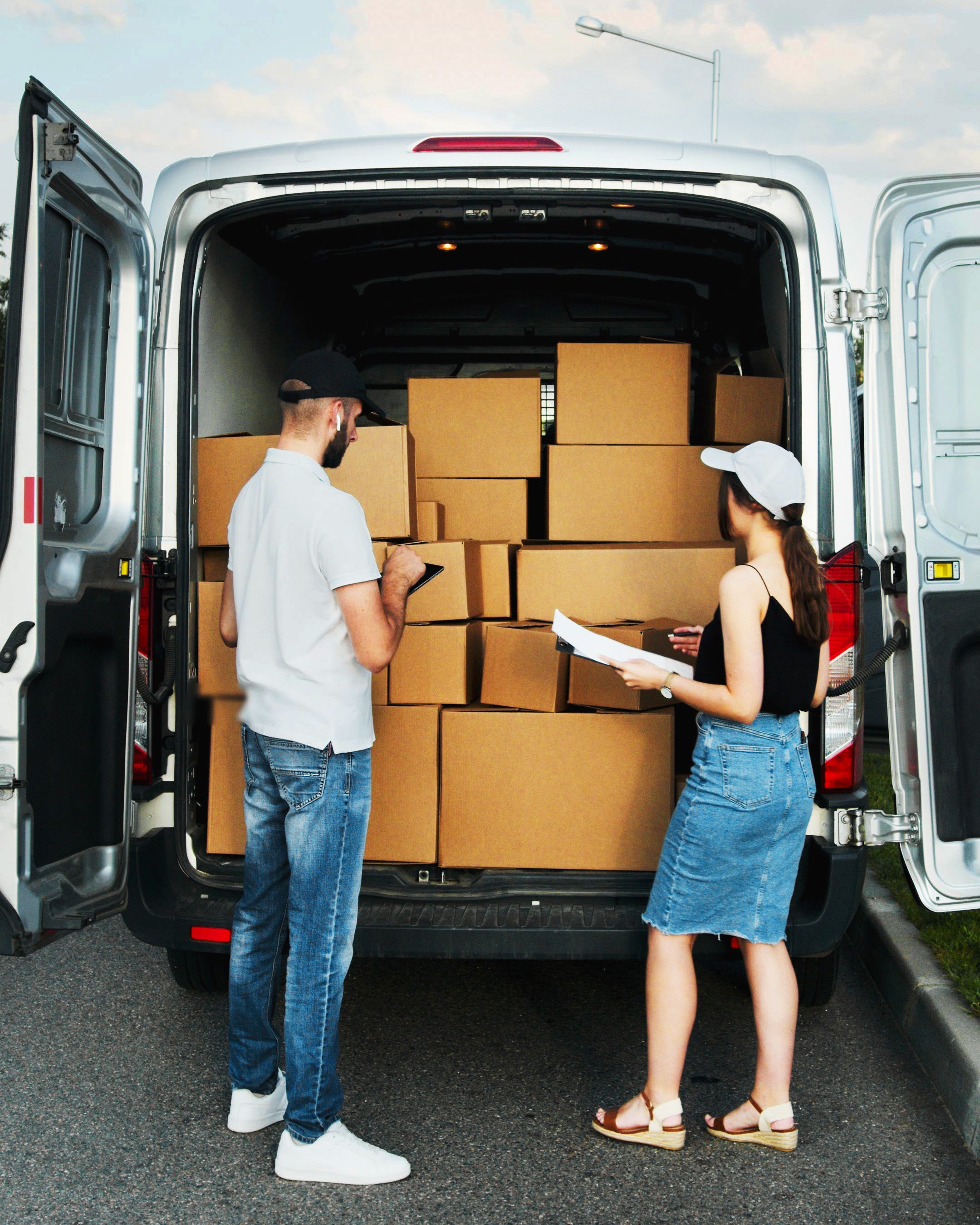 People checking packages in a van.