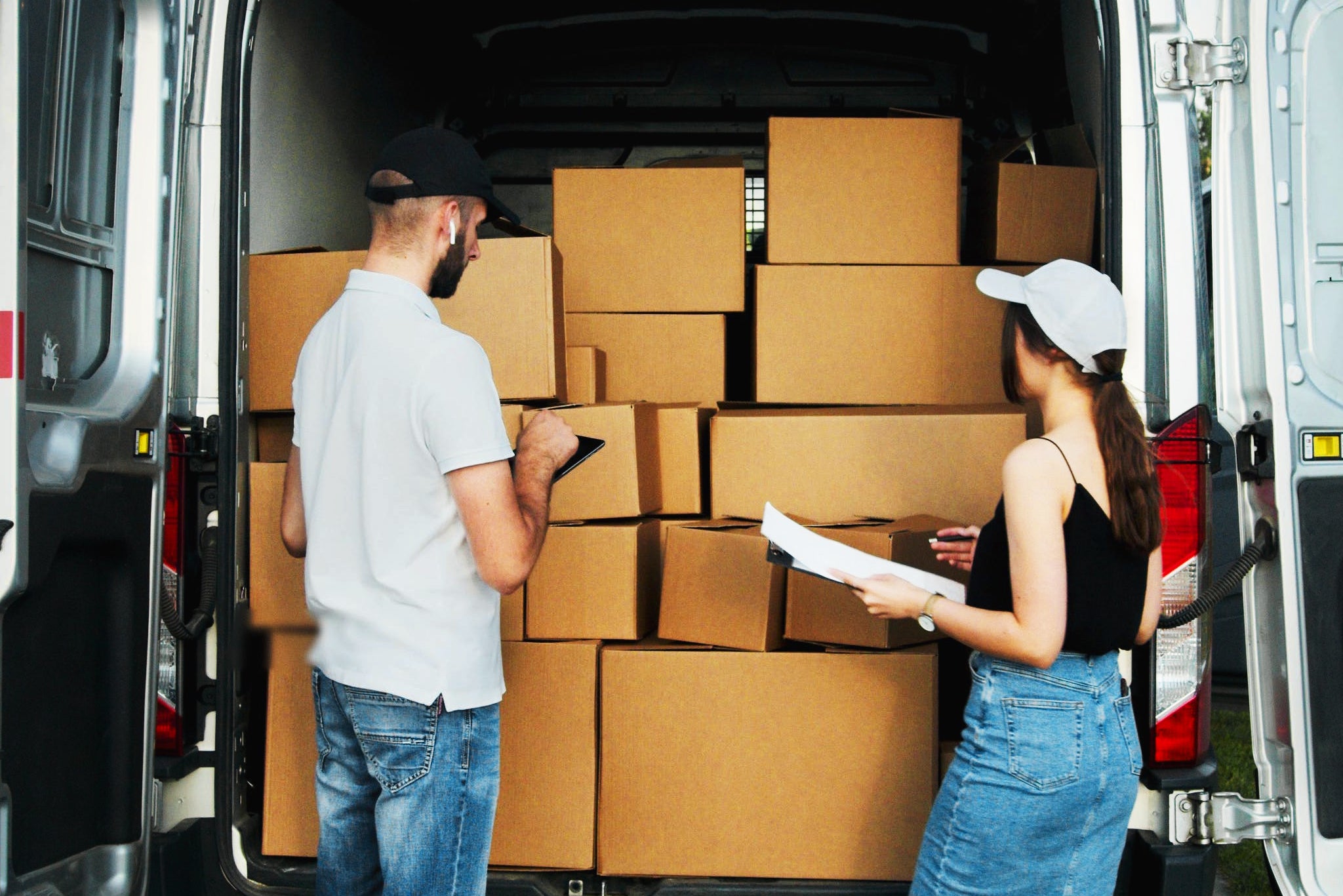 People checking packages in a van.