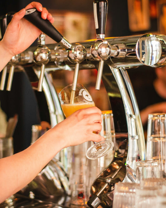 Person pouring  beer from tap into a glass