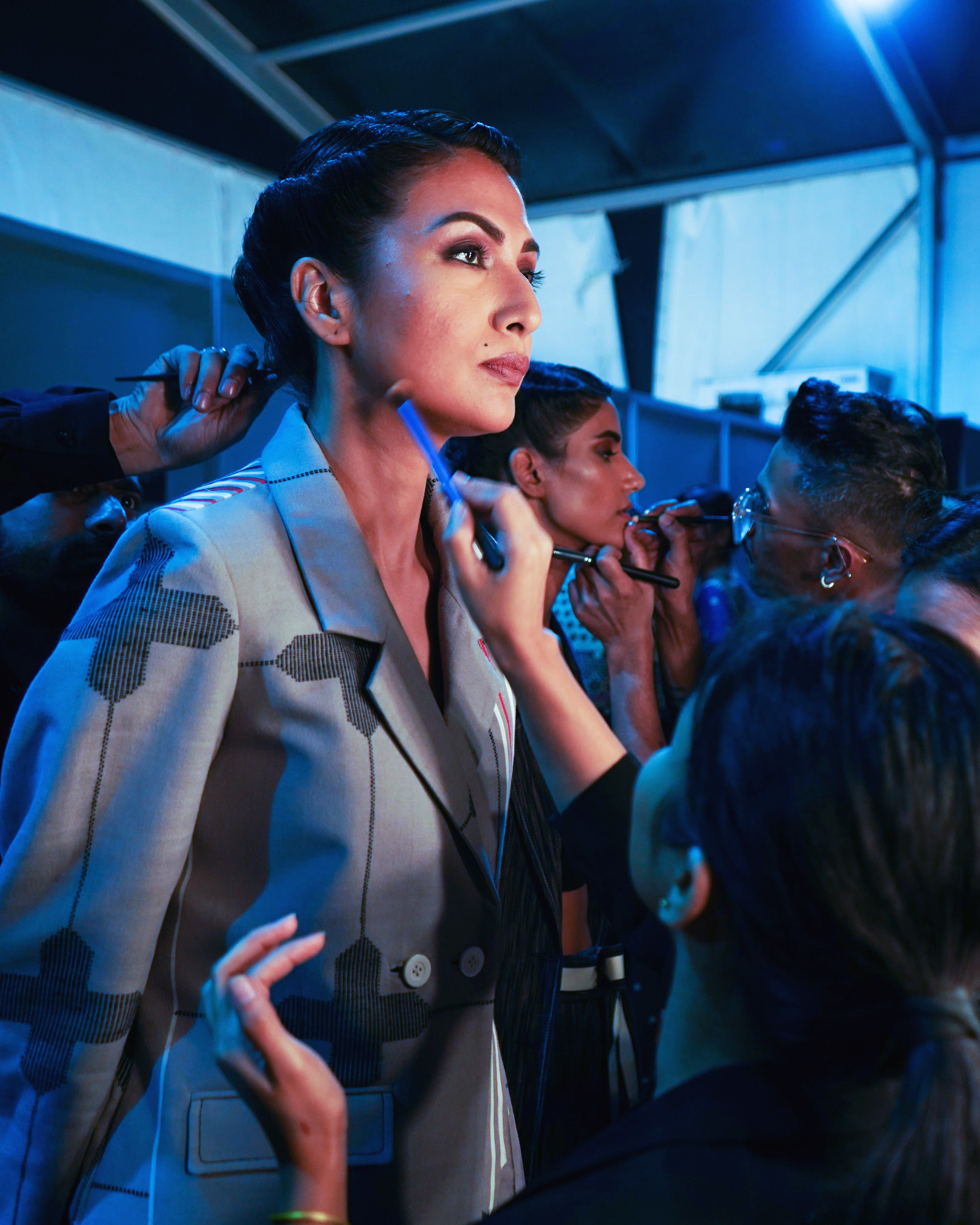 Makeup artists applying makeup on face of actresses.